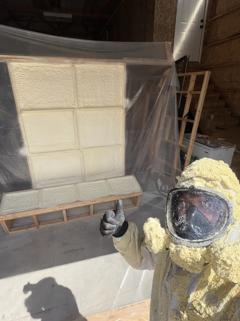 Preston in a foam-covered spray suit and mask giving a thumbs up next to a fresh foam sample