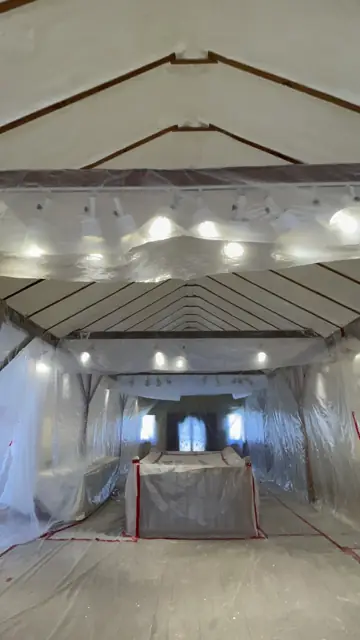 Roof deck sprayed with closed-cell foam, room masked in plastic
