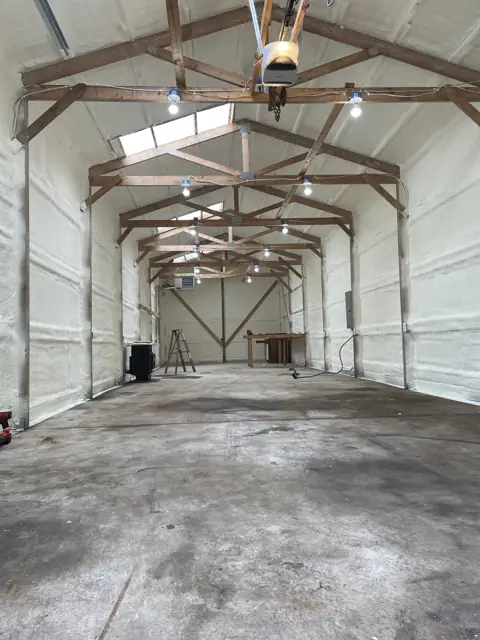 Ag building with foamed walls and roof between steel trusses
